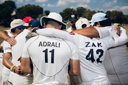 Players huddle during a Washington Cricket League match in Washington, DC. Photo by Noah Willman. `
