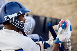 A photo of a player on the sidelines holding a cricket ball at a Washington Cricket League match at West Potomac Park in Washington, DC. Photo by DC editorial photographer Noah Willman. `