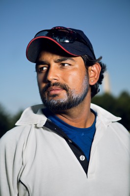 A portrait of a Washington Cricket League player with the Washington Monument in the background at West Potomac Park in Washington, DC. Photo by Noah Willman. `